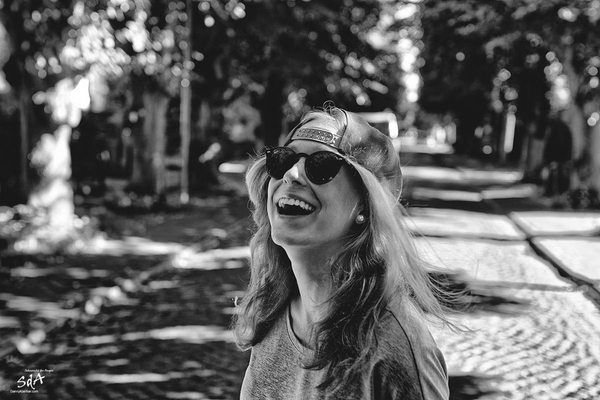 Lachene-junge-Frau-auf-der-Strasse, fotografiert von Danny Koerber für Sehnsucht der Augen.