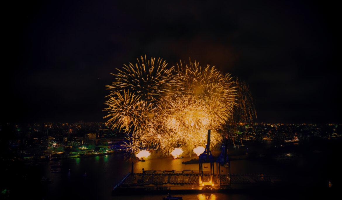 Im Jahr 2025 erleuchtet ein Feuerwerk den Hamburger Hafen und legt für einen kurzen Moment Farbe über Wasser und Architektur. Die Lichtbahnen brechen die Dunkelheit, verweilen in der Langzeitbelichtung und verschmelzen mit den Spiegelungen der Elbe. Zwischen Kränen, Kais und nächtlicher Stille entsteht ein Kontrast aus Bewegung und Schwere, aus flüchtigem Leuchten und dauerhafter Struktur. Die Serie versteht sich als visuelle Beobachtung dieses Übergangs – wenn der Himmel laut wird und der Hafen still bleibt.