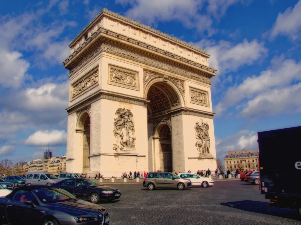 Arc de Triomphe in Paris mit Straßenverkehr und blauem Himmel