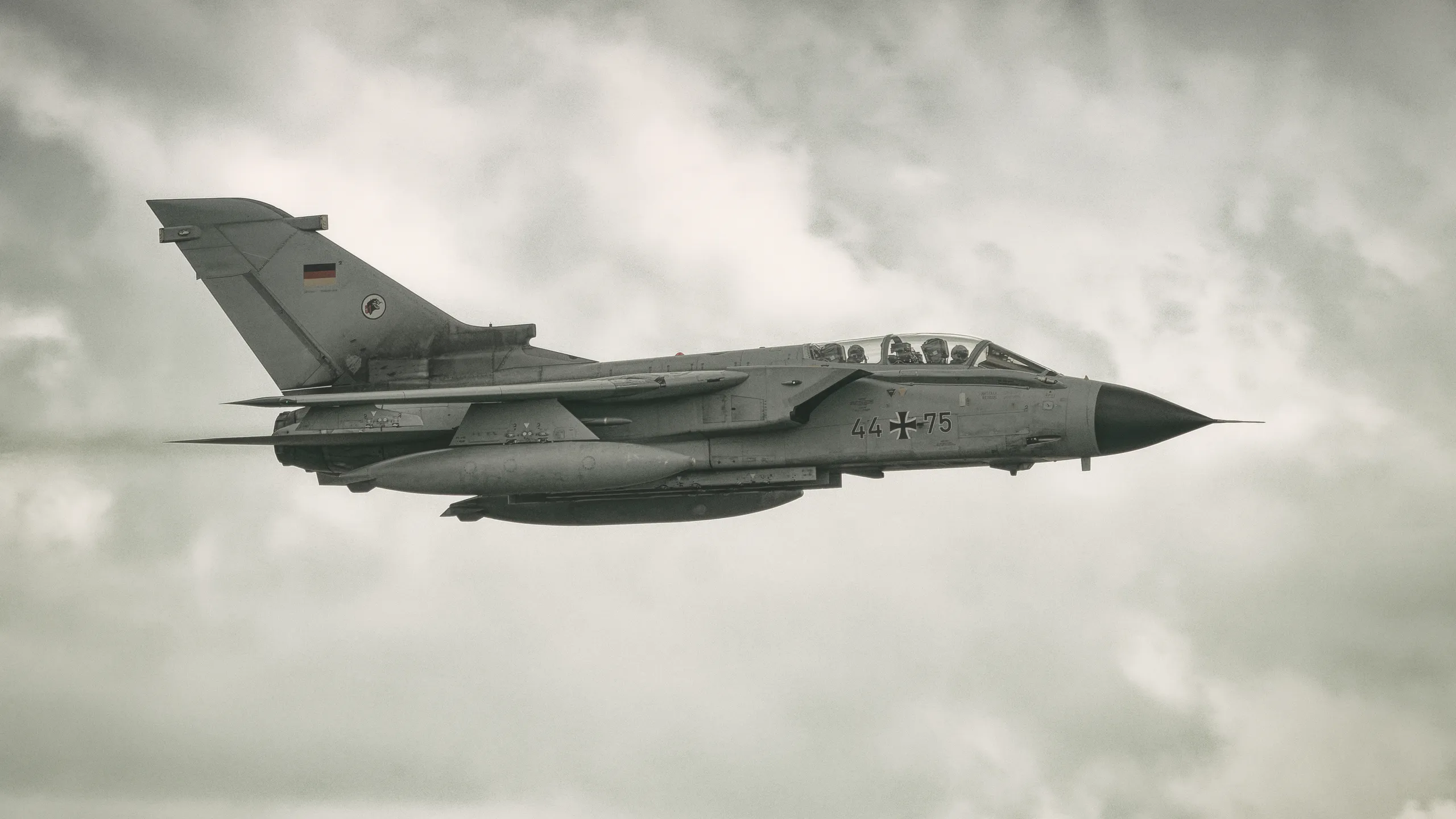Panavia Tornado der Bundeswehr mit der Kennung 44+75 im Seitenflug vor einer grauen Wolkenlandschaft beim Tag der Bundeswehr in Nordholz.