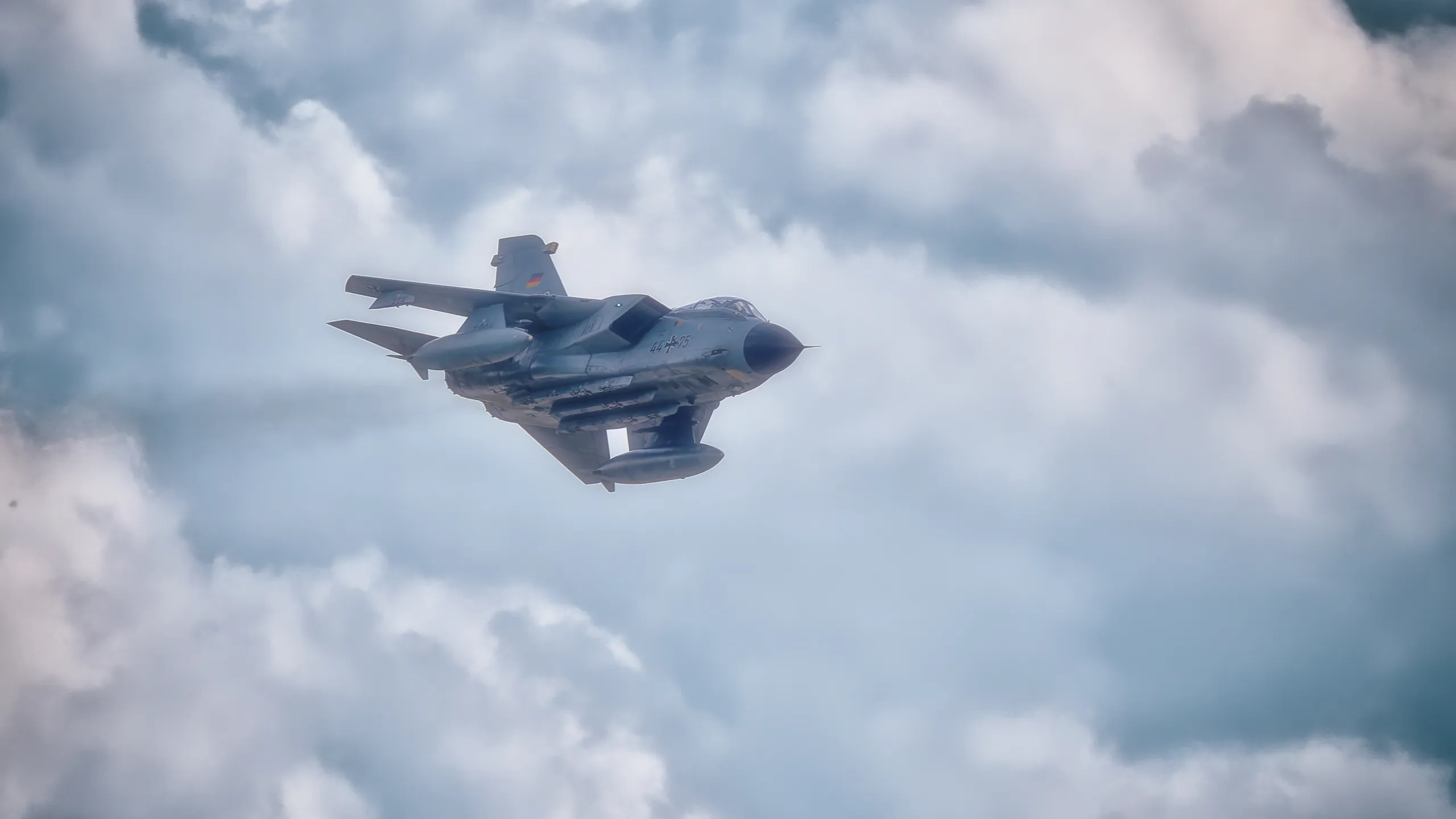 Panavia Tornado der deutschen Luftwaffe während eines Flugmanövers vor blauem Himmel mit dichten Wolken über Nordholz.