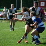 Damenrugby-Spielerin des FC St. Pauli passt den Rugbyball während eines Angriffs an einer Gegenspielerin von Bayern München vorbei.