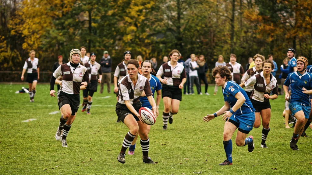 Mehrere Rugbyspielerinnen des FC St. Pauli und Bayern München verfolgen eine Spielerin von St. Pauli mit dem Ball während eines schnellen Angriffs.
