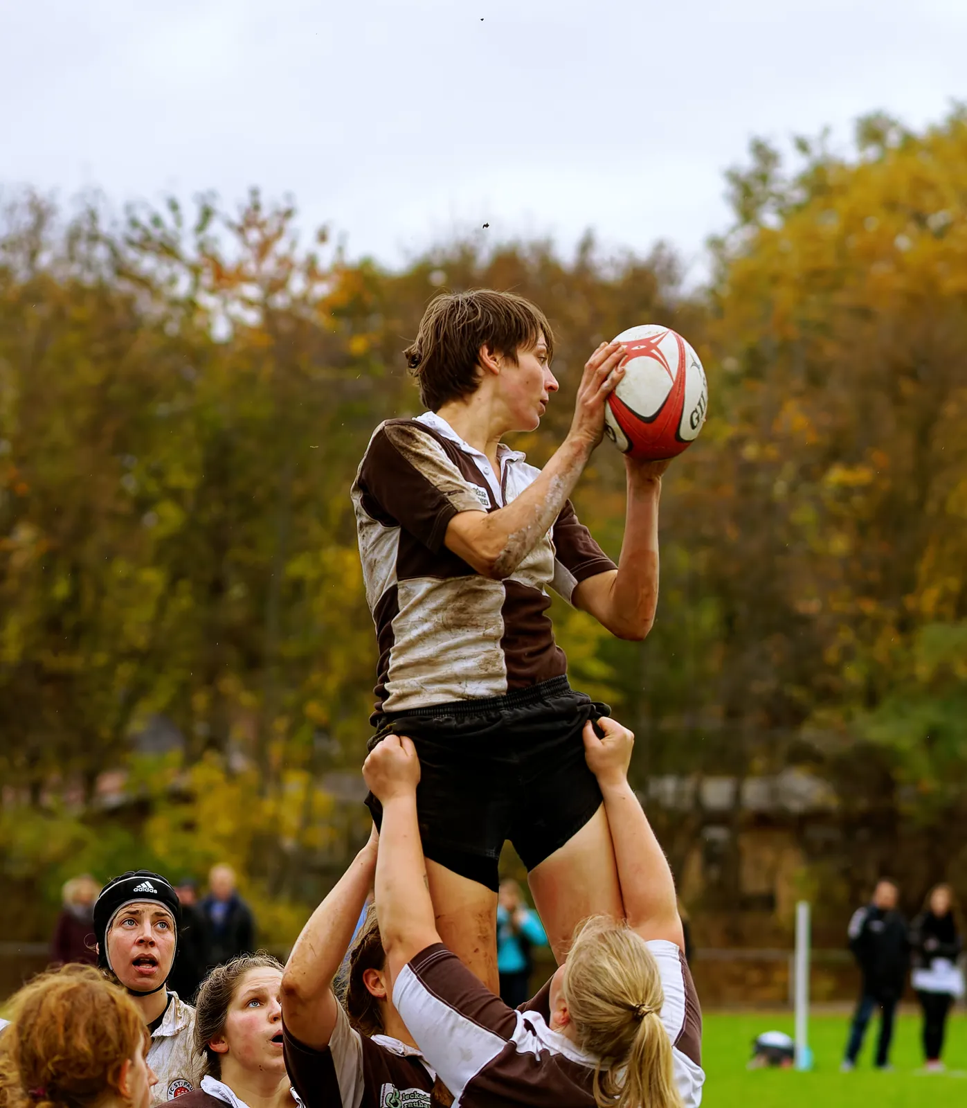 Rugbyspielerin des FC St. Pauli wird bei einer Gasse von ihren Mitspielerinnen hochgehoben und fängt den Rugbyball über den Köpfen der Spielerinnen im Spiel gegen Bayern München.