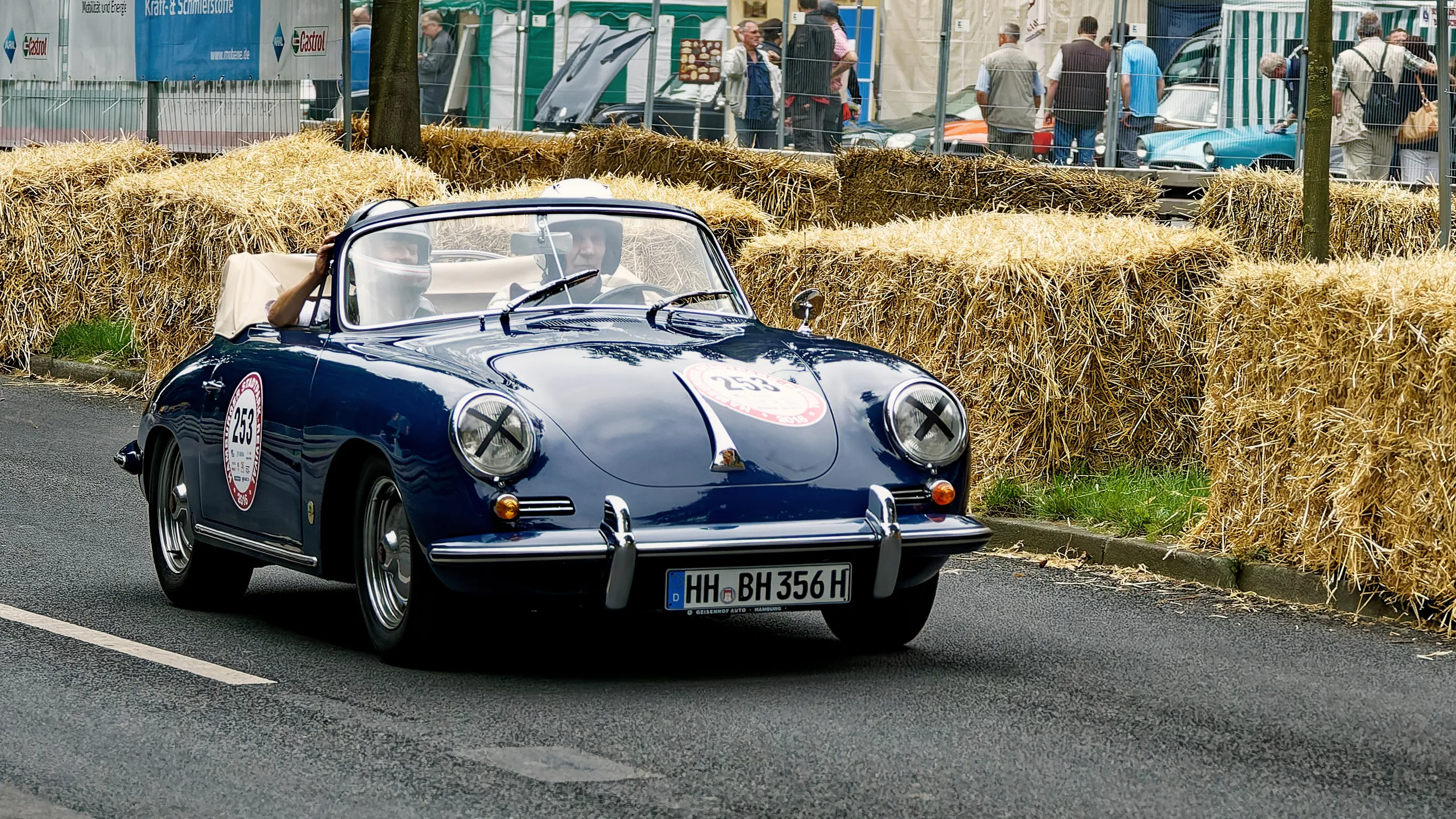 Dunkelblauer Porsche 356 Cabriolet mit Startnummer 253 und zwei Fahrern bei einer historischen Motorsportveranstaltung in Hamburg.