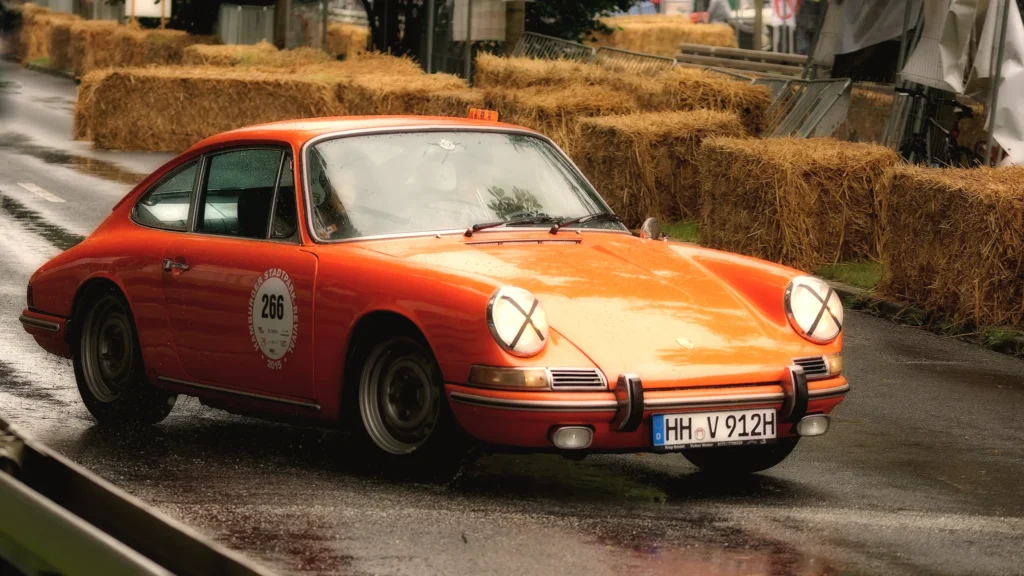 Orangefarbener Porsche 914 mit schwarzem Targadach und Startnummer 555 in einer Kurve beim Hamburger Stadtpark-Revival.