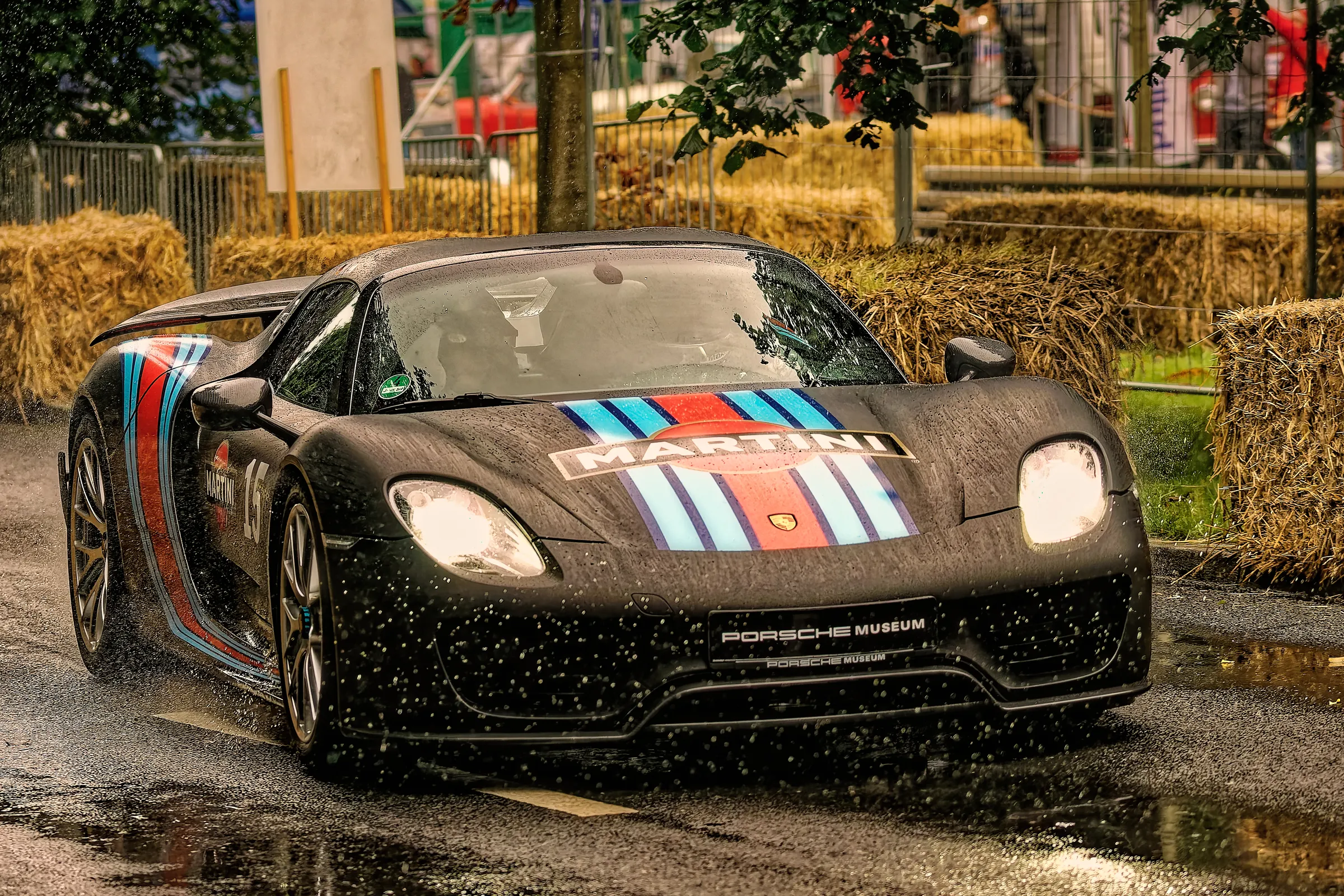 Weißer klassischer Porsche 911 Carrera RS 2.7 im Martini-Racing-Design mit Startnummer 8, Zusatzscheinwerfern und gelben Scheinwerferabdeckungen.