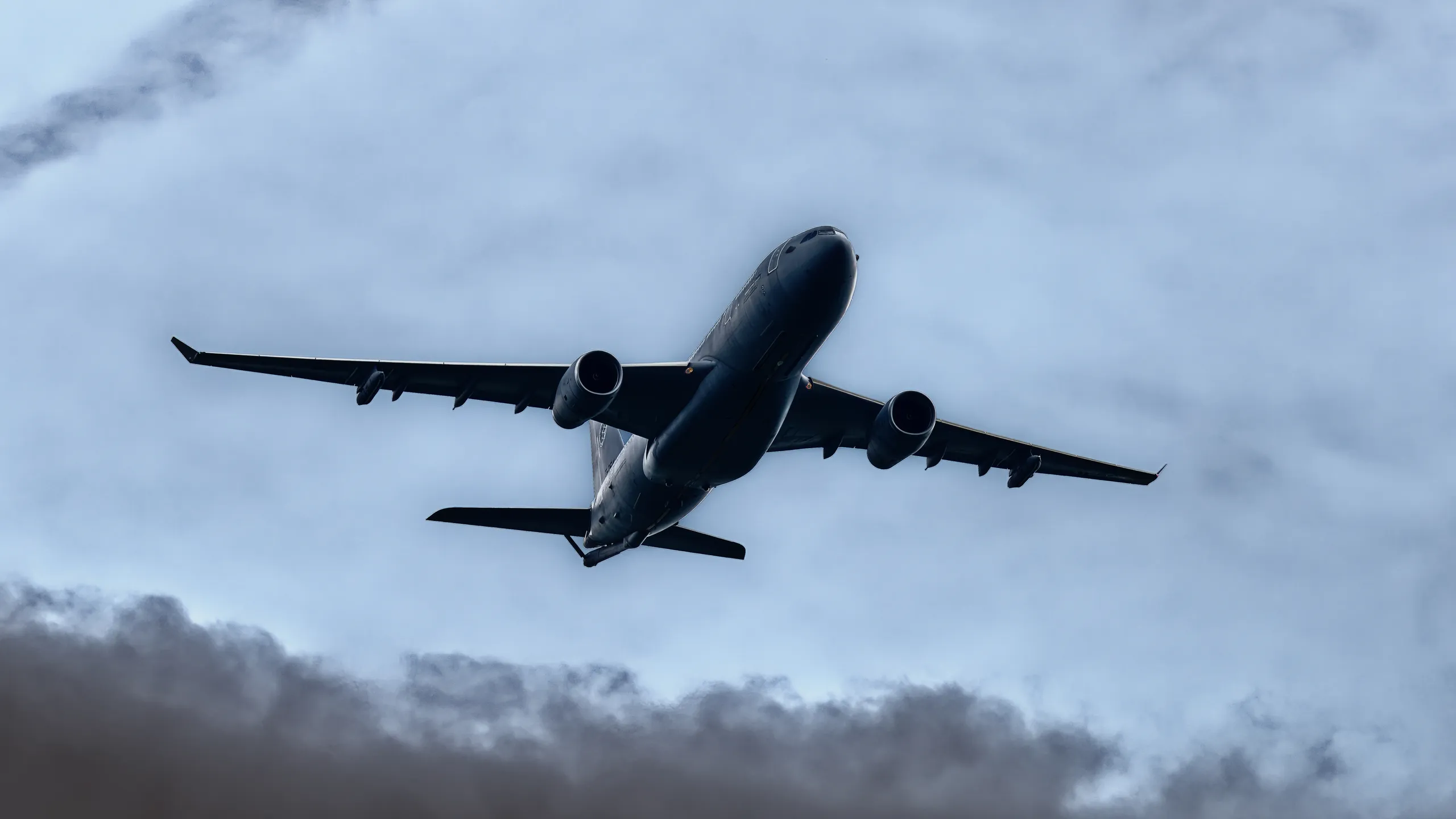 Militärisches Airbus-A330-MRTT-Tankflugzeug aus der Untersicht mit deutlich sichtbaren Triebwerken und Tragflächen vor blauem Himmel.