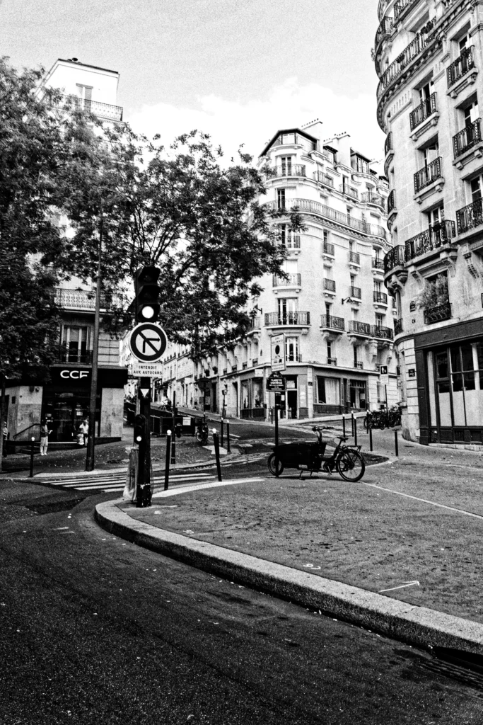 Schwarz-Weiß-Fotografie einer Straßenkreuzung mit historischen Gebäuden in Paris