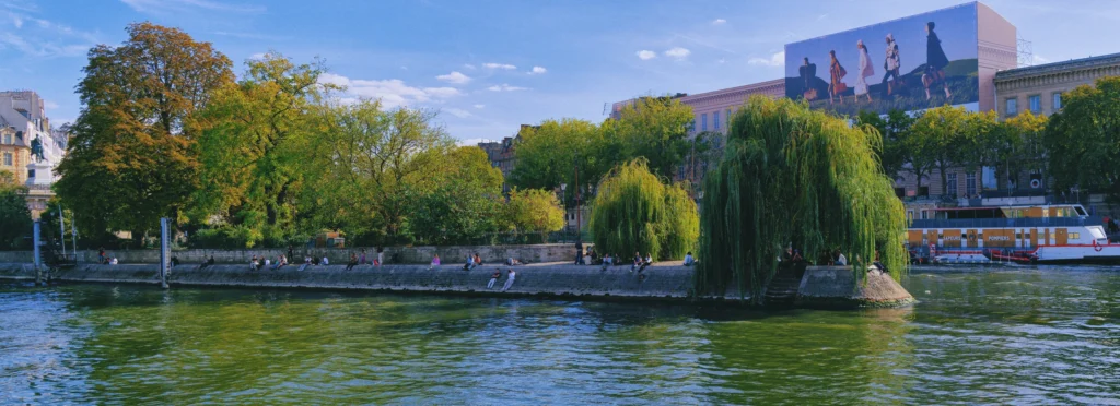 Pariser Stadtleben am Ufer der Seine mit Bäumen und Menschen am Wasser