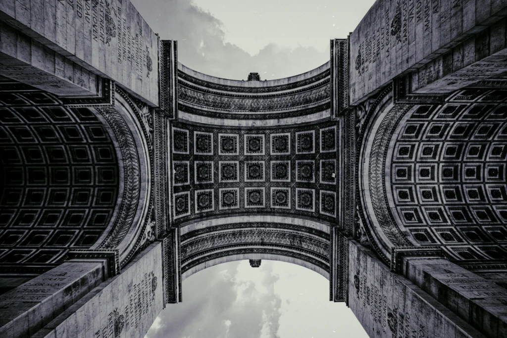 Schwarz-Weiß-Aufnahme der kunstvoll verzierten Unterseite des Arc de Triomphe
